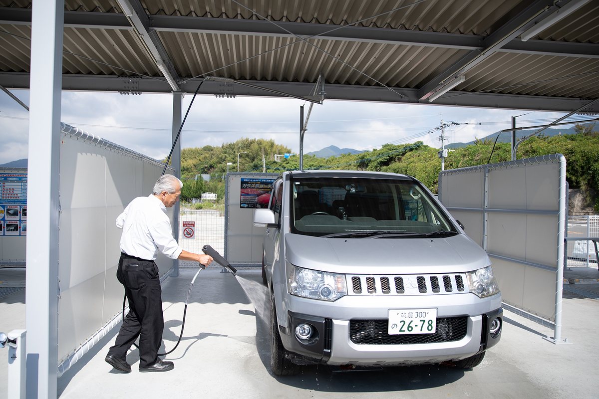 車のまわりを回りながら洗う古谷さん